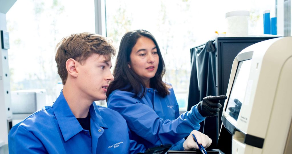 Two Arias Group researchers reviewing data on a lab instrument screen