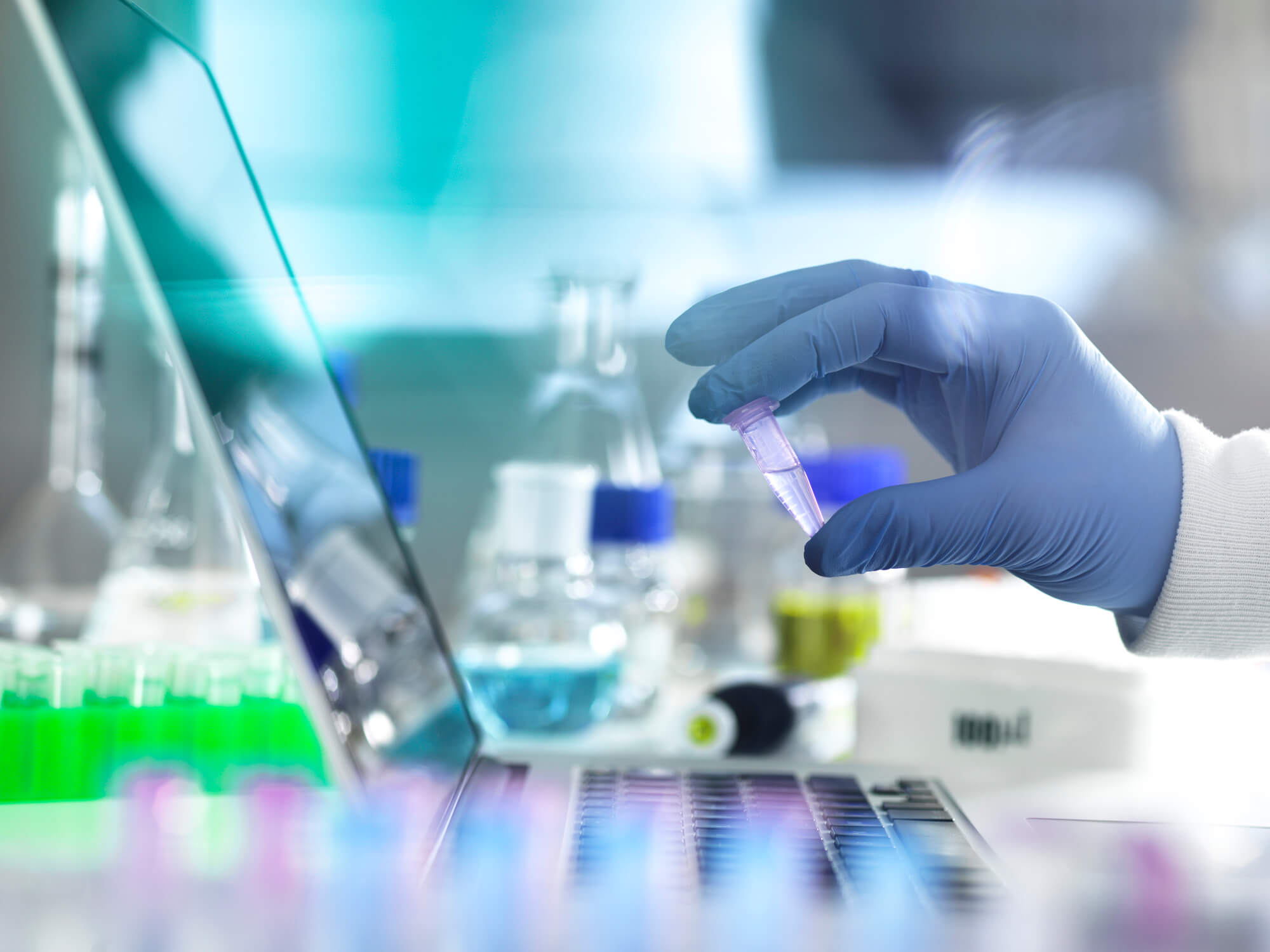 Photo of a scientist examining a vial.