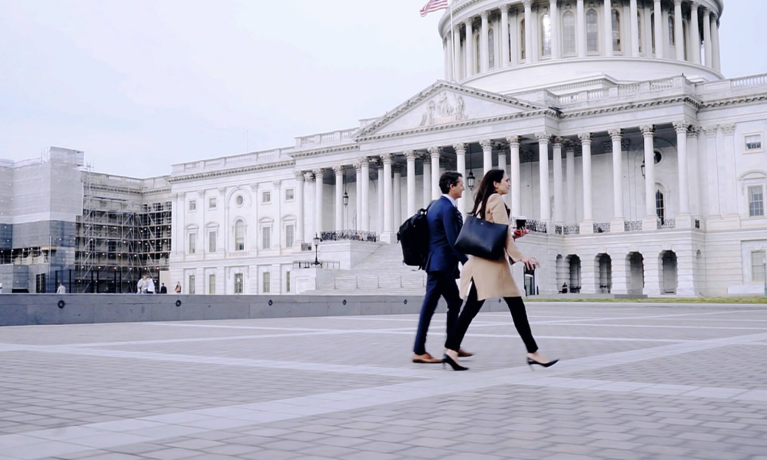 A man and woman walk in front of a government building.