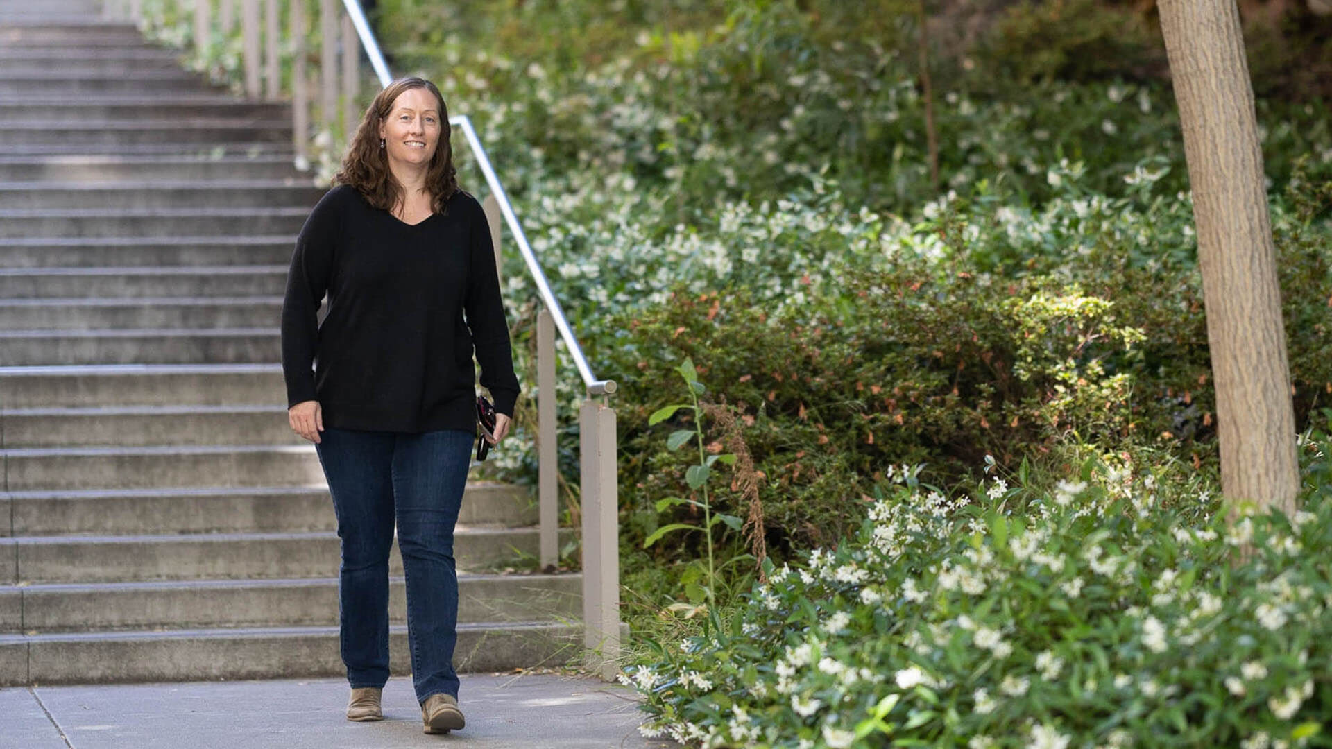 Laura walks along a sidewalk. 