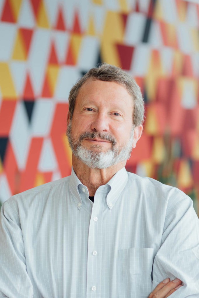 Scott Fraser, vice president of science grant programs at CZI and chairman of the board of openRxiv, stands in front of a colorful geometric-patterned wall.
